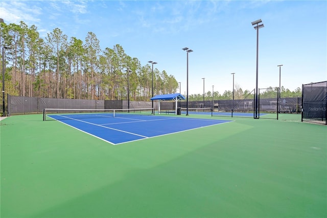 view of tennis court with basketball hoop