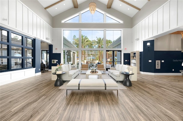 living room featuring beam ceiling, high vaulted ceiling, and light wood-type flooring