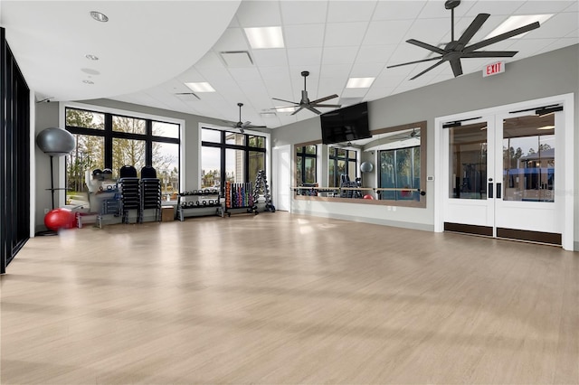 gym featuring light hardwood / wood-style floors, french doors, and ceiling fan