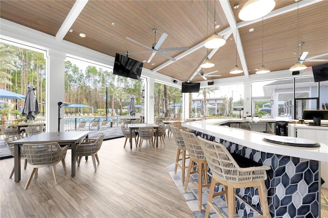 dining area with wood ceiling, light hardwood / wood-style flooring, lofted ceiling with beams, and ceiling fan