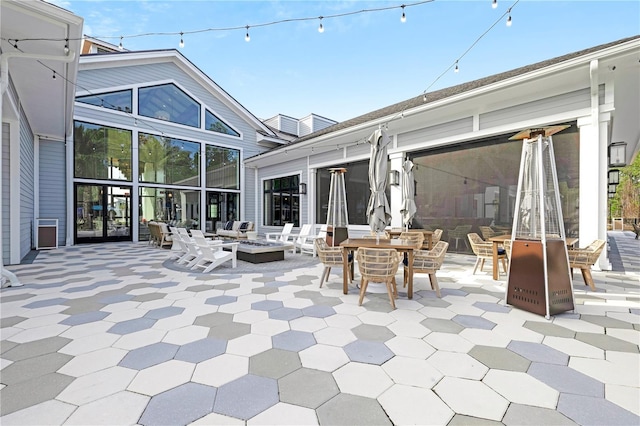 rear view of property with an outdoor fire pit and a patio