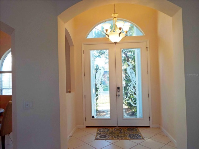 doorway featuring light tile patterned floors, a notable chandelier, and french doors