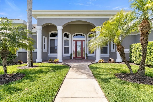 entrance to property featuring a lawn