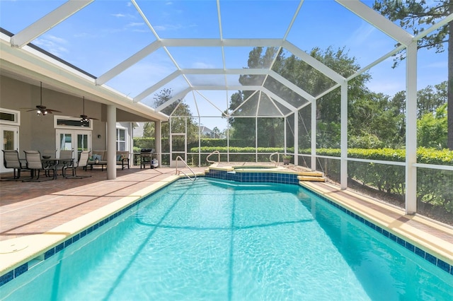 view of pool featuring an in ground hot tub, a lanai, ceiling fan, a patio area, and french doors