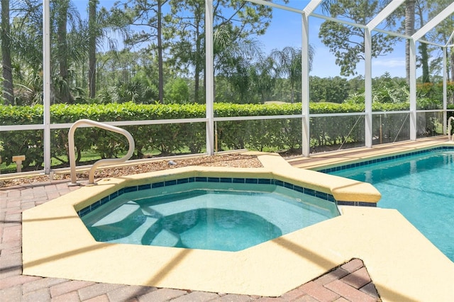 view of pool featuring a lanai and an in ground hot tub