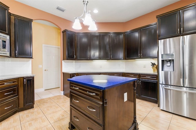 kitchen with hanging light fixtures, dark brown cabinets, and stainless steel fridge