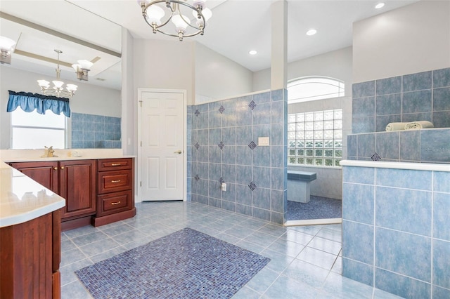 bathroom featuring tile walls, vanity, tile patterned floors, and a chandelier