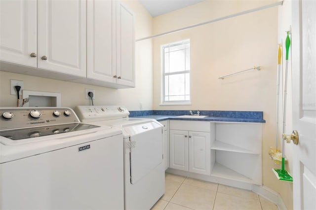 laundry room featuring cabinets, sink, light tile patterned floors, and independent washer and dryer