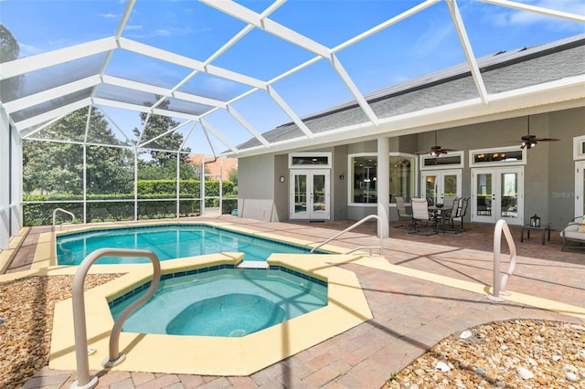 view of swimming pool with ceiling fan, a patio, glass enclosure, french doors, and an in ground hot tub