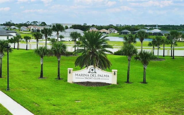 view of home's community with a water view and a lawn