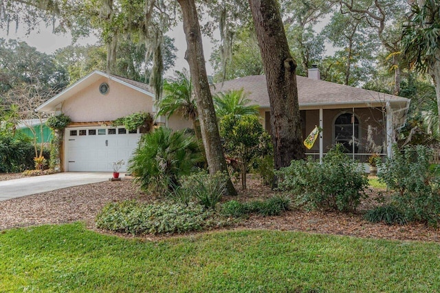 ranch-style house featuring a garage, a front yard, and a sunroom