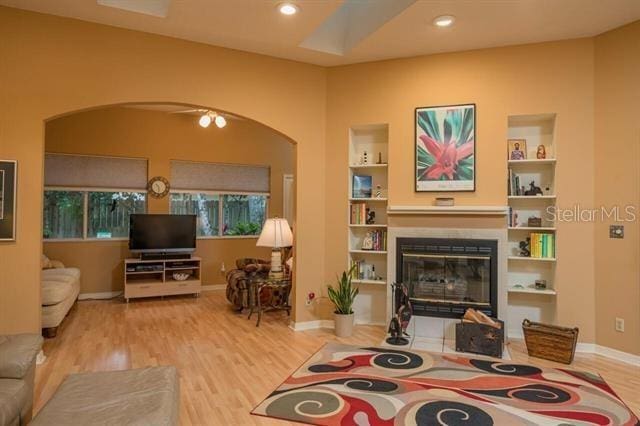 living room featuring light hardwood / wood-style floors and built in shelves