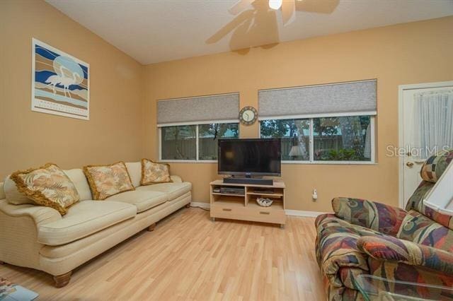 living room featuring hardwood / wood-style floors and ceiling fan