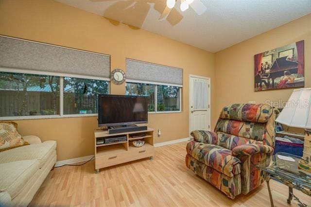 living room with wood-type flooring and ceiling fan