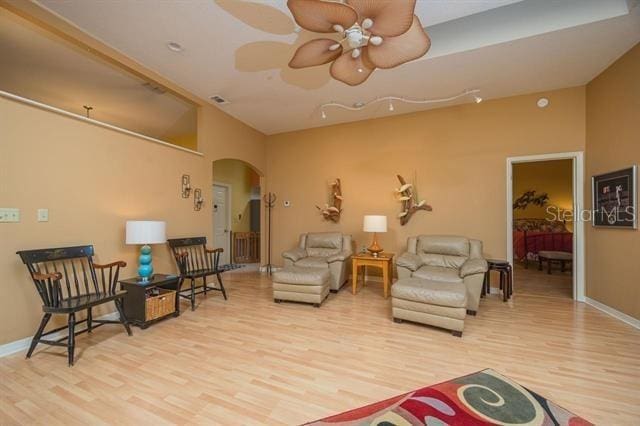 living room with ceiling fan and light wood-type flooring