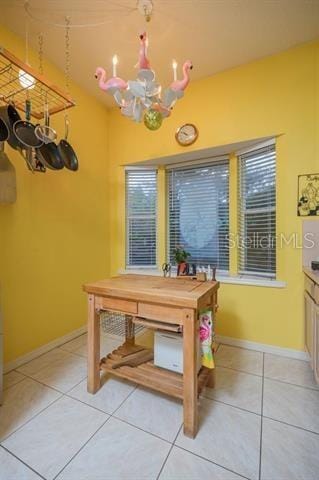 unfurnished dining area with an inviting chandelier and light tile patterned floors