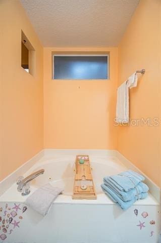 bathroom featuring a bathing tub and a textured ceiling