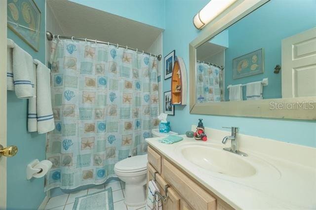 bathroom featuring tile patterned flooring, vanity, walk in shower, and toilet