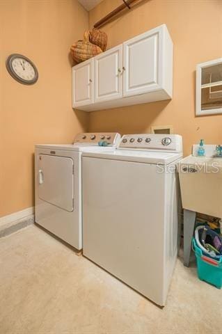 laundry area featuring independent washer and dryer and cabinets