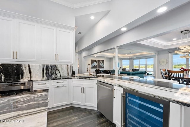 kitchen featuring sink, white cabinets, beverage cooler, decorative backsplash, and stainless steel dishwasher