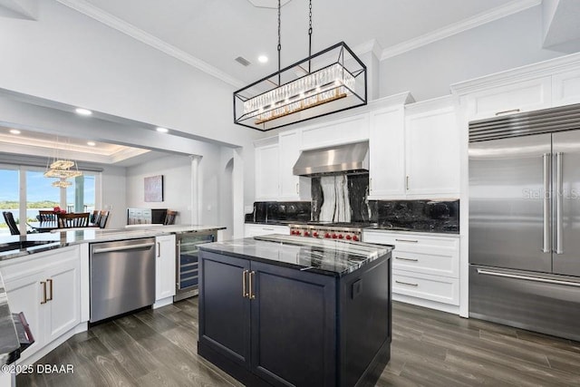 kitchen featuring extractor fan, white cabinetry, hanging light fixtures, a kitchen island, and stainless steel appliances