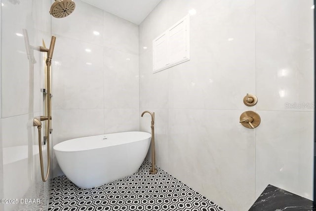 bathroom featuring a bath and tile walls