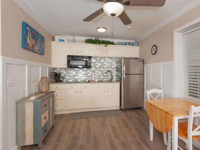 kitchen featuring sink, crown molding, tasteful backsplash, wood-type flooring, and black appliances