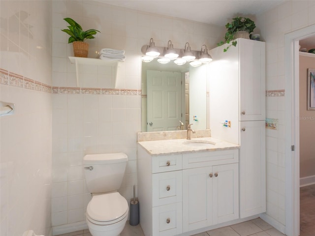 bathroom with tile walls, vanity, tile patterned floors, and toilet