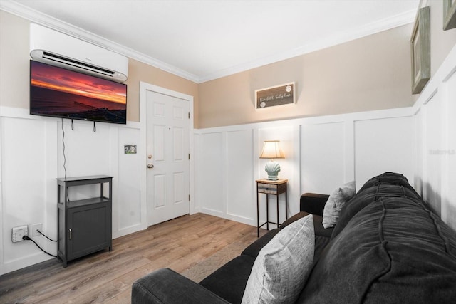 living room with ornamental molding, a wall mounted AC, and light hardwood / wood-style flooring