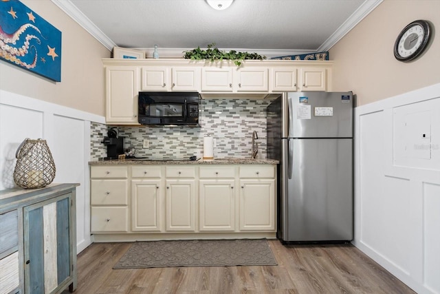 kitchen featuring crown molding, stone countertops, sink, and black appliances