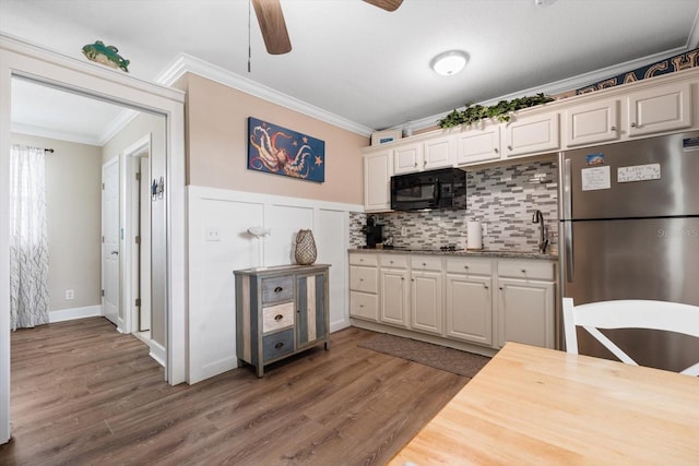 kitchen featuring crown molding, dark hardwood / wood-style floors, stainless steel fridge, and backsplash