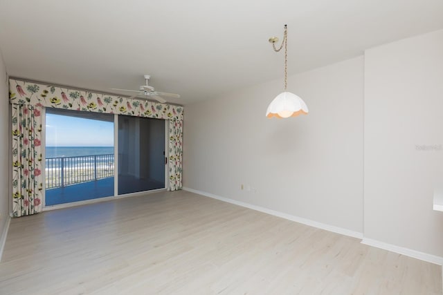 unfurnished room featuring a water view, ceiling fan, and light hardwood / wood-style flooring