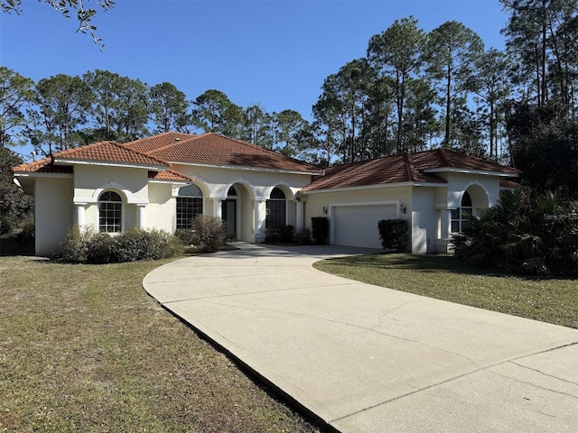 mediterranean / spanish-style home featuring a garage and a front yard