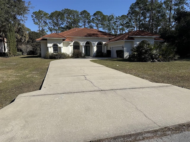 mediterranean / spanish home with a garage and a front lawn