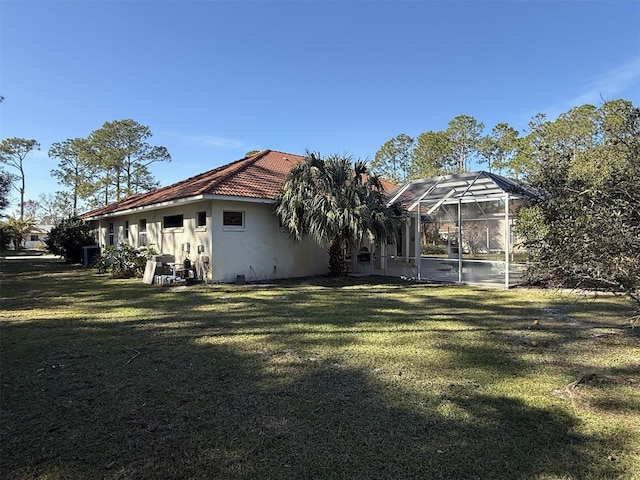 rear view of house with a lanai and a lawn