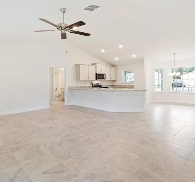 kitchen featuring a peninsula, white cabinets, open floor plan, hanging light fixtures, and appliances with stainless steel finishes