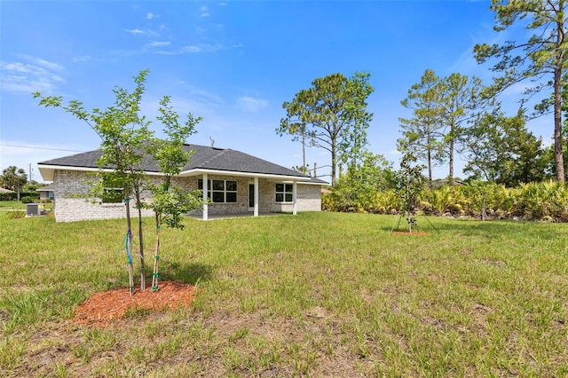 13 Primrose Ln, Palm Coast, FL 32164 - rear view of property with a lawn, a patio, brick siding, and central AC