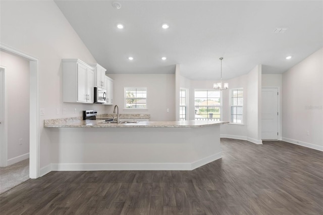 13 Primrose Ln, Palm Coast, FL 32164 - kitchen featuring appliances with stainless steel finishes, dark wood-style flooring, a chandelier, a peninsula, and baseboards