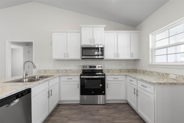 13 Primrose Ln, Palm Coast, FL 32164 - kitchen featuring appliances with stainless steel finishes, lofted ceiling, a sink, white cabinets, and dark wood-type flooring
