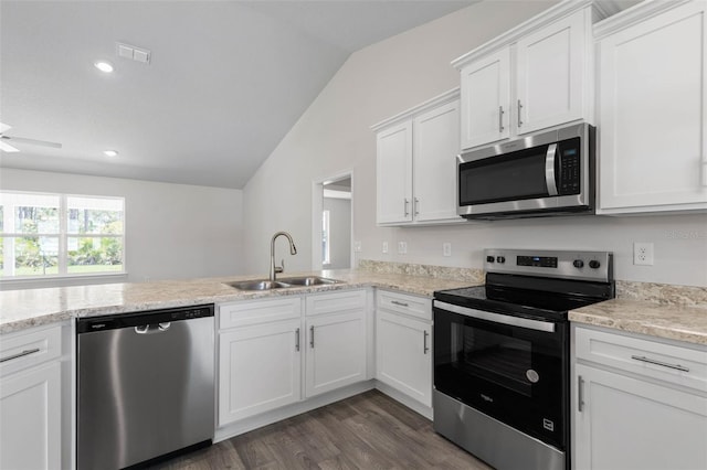 13 Primrose Ln, Palm Coast, FL 32164 - kitchen with stainless steel appliances, a sink, lofted ceiling, dark wood-style flooring, and white cabinetry