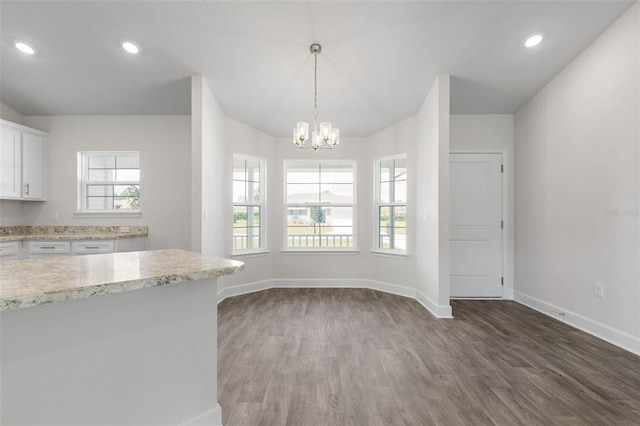 13 Primrose Ln, Palm Coast, FL 32164 - kitchen with wood finished floors, baseboards, white cabinets, a chandelier, and light stone countertops