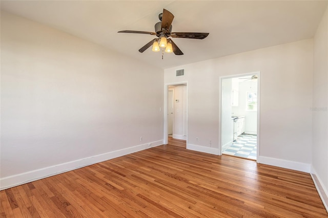 unfurnished bedroom with ceiling fan, connected bathroom, and light wood-type flooring