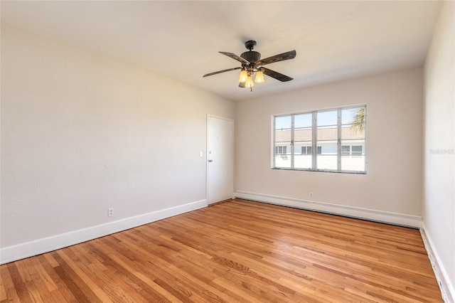 spare room featuring a baseboard radiator, light hardwood / wood-style floors, and ceiling fan