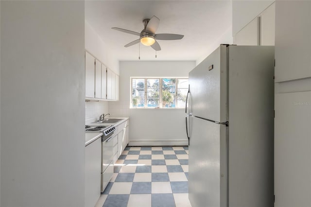 kitchen with electric stove, sink, tasteful backsplash, white cabinets, and white fridge