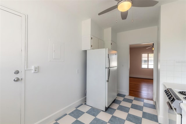 kitchen featuring electric stove, ceiling fan, refrigerator, and white cabinets