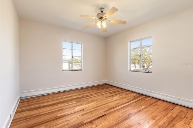 empty room featuring a healthy amount of sunlight, ceiling fan, and light hardwood / wood-style flooring