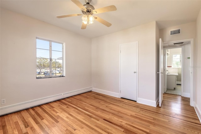 unfurnished bedroom featuring ceiling fan, a closet, light hardwood / wood-style flooring, and a baseboard heating unit