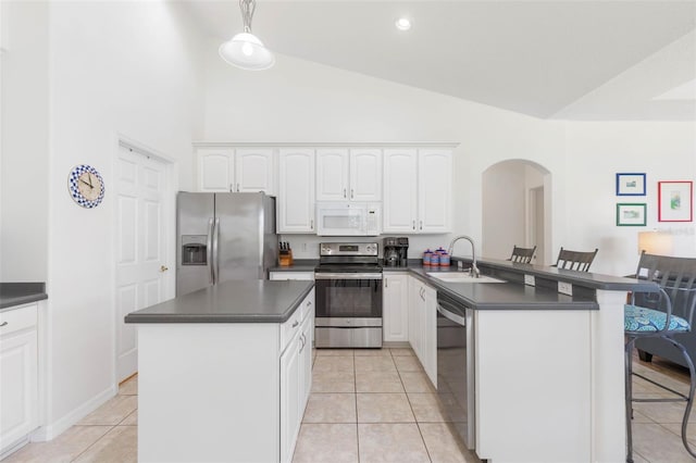 kitchen with sink, a breakfast bar area, white cabinetry, decorative light fixtures, and appliances with stainless steel finishes