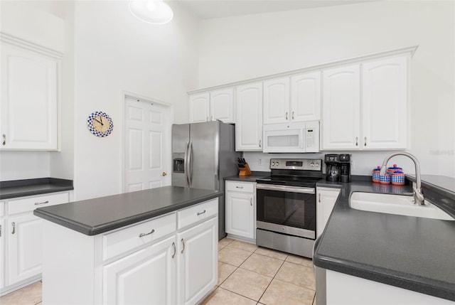 kitchen with sink, light tile patterned floors, white cabinetry, stainless steel appliances, and a center island