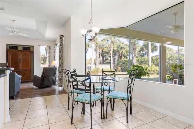 tiled dining area with ceiling fan with notable chandelier